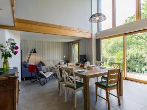 a dining room and living room with a table and chairs at Chalet Ty Coat by Interhome in La Forêt-Fouesnant +25 photos