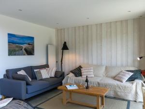 a living room with a couch and a coffee table at Chalet Ty Coat by Interhome in La Forêt-Fouesnant