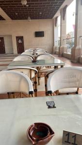 una fila di tavoli e sedie con un telecomando di فندق جراند كليوباترا الساحل الشمالى المنتزه ك80 a El Alamein
