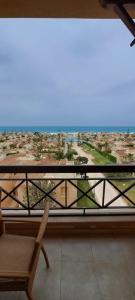 una silla en el balcón con vistas a la ciudad en فندق جراند كليوباترا الساحل الشمالى المنتزه ك80, en El Alamein