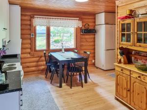 La cuisine est équipée d'une table, de chaises et d'un réfrigérateur. dans l'établissement Holiday Home Saarenranta by Interhome, à Koivisto