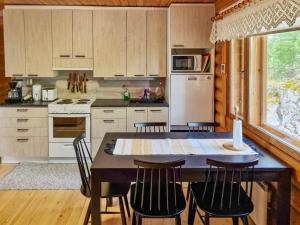 - une cuisine avec une table et des chaises dans la chambre dans l'établissement Holiday Home Saarenranta by Interhome, à Koivisto