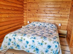ein Schlafzimmer mit einem Bett in einer Holzwand in der Unterkunft Holiday Home Saarenranta by Interhome in Koivisto