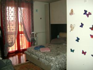 1 dormitorio con 1 cama con mariposas en la pared en Casa Marblu via Cairoli, 47 Corciano, en Corciano