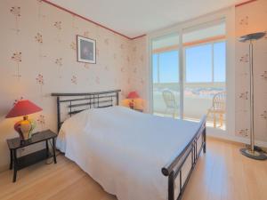 - une chambre avec un lit blanc et une grande fenêtre dans l'établissement Apartment L'Escale Vendée Globe - LSD300 by Interhome, à Les Sables-dʼOlonne