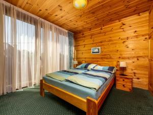 バラトンケレストゥールにあるHoliday Home Brico by Interhomeの木製の部屋にベッド1台が備わるベッドルーム1室があります。