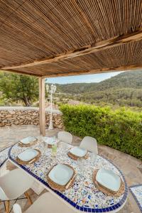 a table and chairs on a patio with a view at Villa Sa Bassa, Amazing seaviews and great Pool in Portinatx