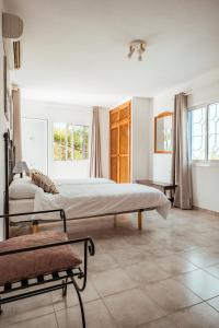 a bedroom with a large bed and two windows at Villa Sa Bassa, Amazing seaviews and great Pool in Portinatx