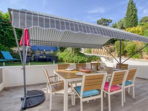 a table and chairs under an umbrella on a patio at Holiday Home De Manou - SFP135 by Interhome in Six-Fours-les-Plages