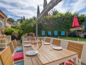 a wooden table and chairs on a patio at Holiday Home De Manou - SFP135 by Interhome in Six-Fours-les-Plages