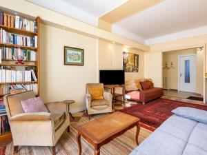 uma sala de estar com um sofá e cadeiras e uma televisão em Apartment Le Provence by Interhome em Dinard