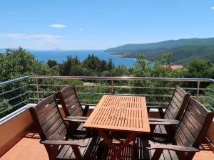 a wooden table and four chairs on a balcony at Apartment Magnolia - RAC167 by Interhome in Rabac