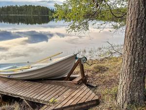 a boat sitting on a dock next to a tree at Holiday Home Harjula by Interhome in Nissi