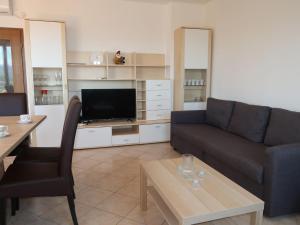 a living room with a couch and a tv at Apartment Magnolia - RAC167 by Interhome in Rabac