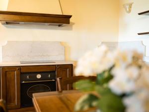 サン・マルティーノ・デッラ・バッターリアにあるApartment Corte Arcadia-3 by Interhomeのキッチン(コンロ、花のテーブル付)