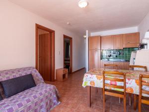 eine Küche und ein Wohnzimmer mit einem Tisch und einem Sofa in der Unterkunft Apartment Casa Vecchi by Interhome in Moriani Plage