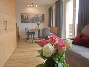 a living room with a vase of pink and white flowers at Apartment Ladis-7 by Interhome in Ladis