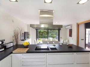 cocina con armarios blancos y encimera negra en Holiday Home Volca by Interhome, en Olot