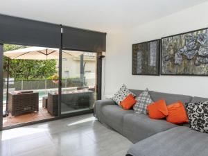 ein Wohnzimmer mit einem grauen Sofa und orangefarbenen Kissen in der Unterkunft Holiday Home Volca by Interhome in Olot