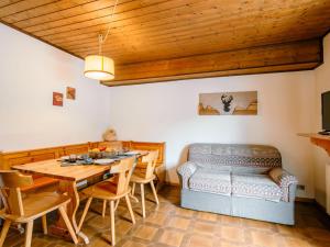 ein Esszimmer mit einem Tisch und einem Sofa in der Unterkunft Apartment Mantina-2 by Interhome in Moena