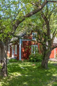 une maison rouge avec un arbre devant elle dans l'établissement Holiday Home Ebbabolet by Interhome, à Tibro