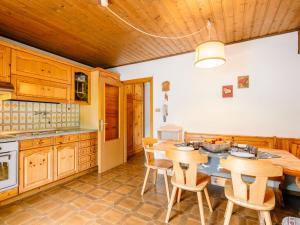 eine Küche mit Holzschränken sowie einem Tisch und Stühlen in der Unterkunft Apartment Mantina-2 by Interhome in Moena