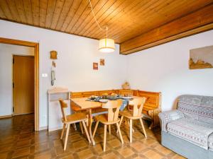 ein Wohnzimmer mit einem Tisch, Stühlen und einem Sofa in der Unterkunft Apartment Mantina-2 by Interhome in Moena