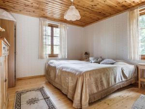 um quarto com uma cama grande e um tecto de madeira em Chalet Kasen Sjökanten by Interhome em Färgelanda