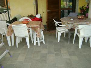 una mesa con sillas blancas y una mesa con mantel en Casa Marblu via Cairoli, 47 Corciano, en Corciano