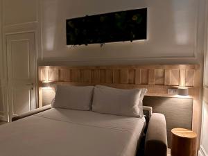 - une chambre avec un lit blanc et une tête de lit en bois dans l'établissement Eco Urban B&B, à Florence