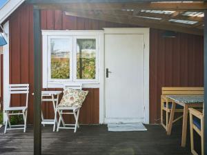 un porche con sillas, una puerta y una mesa en Holiday Home Bergkvara - SND033 by Interhome, en Bergkvara