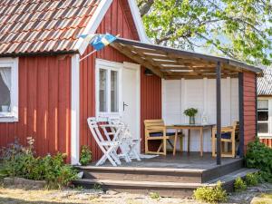 a red and white shed with a table on a deck at Holiday Home Bergkvara by Interhome in Bergkvara