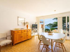 une cuisine avec une table et des chaises ainsi qu'une salle à manger dans l'établissement Apartment Les Floralies II-3 by Interhome, au Lavandou