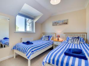 een slaapkamer met 2 bedden en een raam bij Holiday Home Lilac by Interhome in Padstow