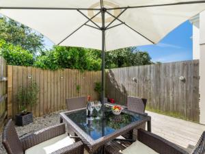 een patio met een tafel en een parasol bij Holiday Home Lilac by Interhome in Padstow