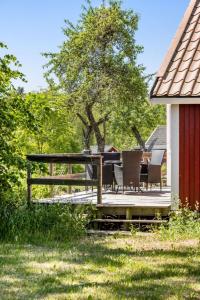 Kalvsvik的住宿－Holiday Home Skärvudde Torpet - SND083 by Interhome，木制甲板上配有桌椅