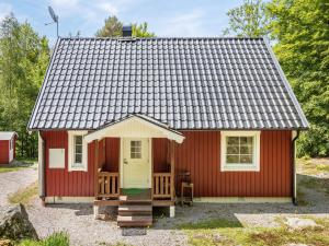 een rood tiny house met een gele deur bij Holiday Home Erikstorp Tvåan by Interhome in Olofström