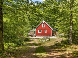 un granero rojo en medio de un bosque en Holiday Home Erikstorp Tvåan by Interhome, en Olofström