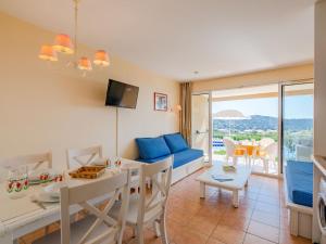 a living room with a table and a dining room at Apartment Le Hameau des Issambres-5 by Interhome in Les Issambres