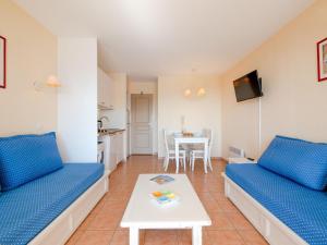 レ・ズィサンブルにあるApartment Le Hameau des Issambres-5 by Interhomeのリビングルーム(青いソファ2台、テーブル付)