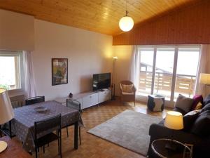 un soggiorno con un tavolo e una TV di Apartment Belmont Est 80 by Interhome a Vermala