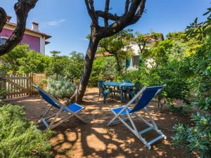 a patio with a table and chairs under a tree at Holiday Home I Lecci by Interhome in Castiglioncello