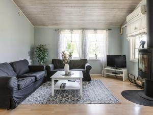 ein Wohnzimmer mit einem Sofa und einem TV in der Unterkunft Holiday Home Skärvudde Huset - SND084 by Interhome in Kalvsvik