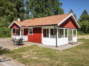 einen roten und weißen Schuppen mit einem Tisch und Stühlen in der Unterkunft Holiday Home Skärvudde Huset - SND084 by Interhome in Kalvsvik
