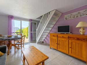 a living room with a dining table and a tv at Holiday Home Maison de la Plage by Interhome in Carnac-Plage