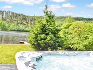 a jacuzzi tub sitting next to a lake at Holiday Home Nuppulanranta 14 by Interhome in Jämsä