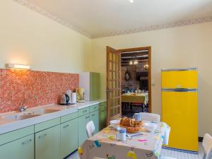 ラ・フォレ・フエナンにあるHoliday Home Ker Glaz by Interhomeのキッチン(テーブル、黄色い冷蔵庫付)