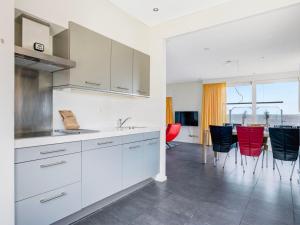eine Küche mit weißen Schränken und roten Stühlen in der Unterkunft Holiday Home Jachthaven Oostmahorn by Interhome in Anjum