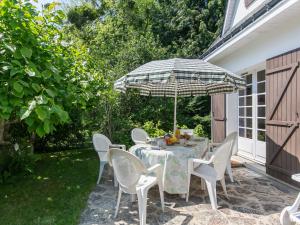 un tavolo e sedie con ombrellone su un patio di Holiday Home Bellevue - MSR103 by Interhome a Moëlan-sur-Mer
