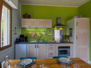 コンカルノーにあるHoliday Home Gîte au Jardin - CCN106 by Interhomeの緑の壁のキッチン(木製テーブル付)